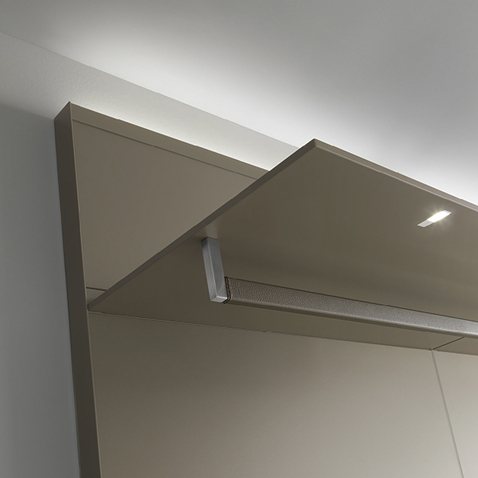 Pannello a parete in vetro laccato opaco tortora con illuminazione a led, ripiano laccato opaco tortora con faretto a led integrato; asta portabiti in acciaio inox spazzolato rivestita in cuoio rigenerato argilla.