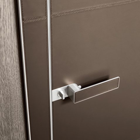 Versione in alluminio lucido e cuoio fango con cucitura in cotone abbinata.