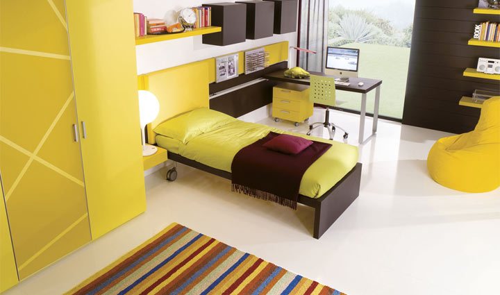 La contemporaneità della architettura abitativa, grazie al sistema d'arredo Zoe, viene esaltata nei suoi volumi. In questo universo di forme, si inseriscono in modo naturale, lo scrittoio scorrevole, gli elementi contenitore a muro in frassino laccato tinta wengè e l'armadio con anta battente 