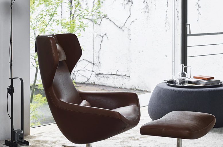 Un angolo lettura dai volumi sottili e le superfici fluenti, davanti alla luminosa vetrata. Poltrona Metropolitan '14 di Jeffrey Bernett.