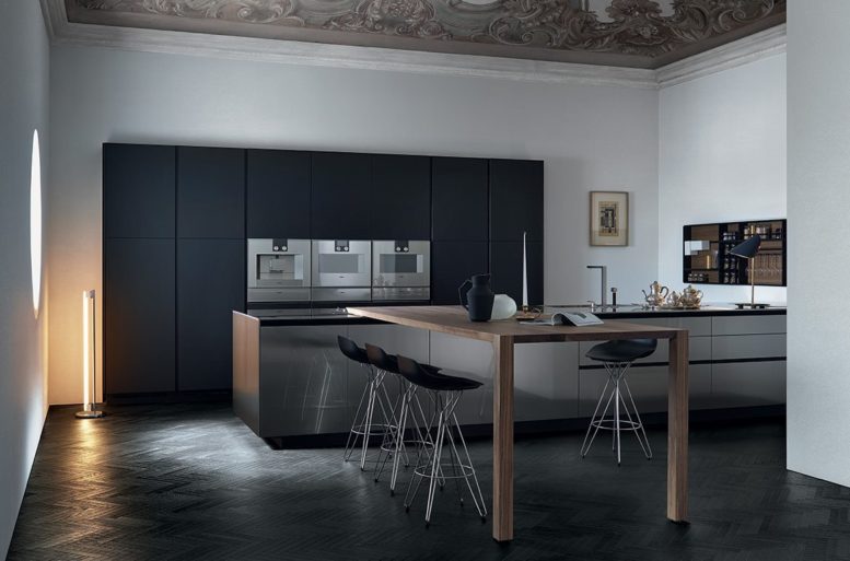 I materiali sono riflettenti nelle superfici piane (olmo nero, vetro blu, marmo levigato), a cui fanno eco le sedute dalle linee curve. Cucina Twelve Varenna