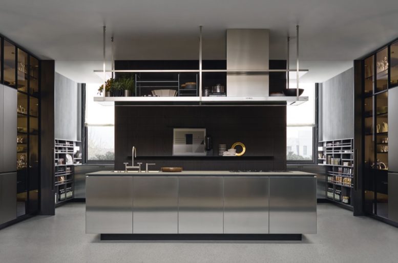 La cucina è uno spazio centrale nell'appartamento. L'aspetto è geometrico, ma si inserisce nel contesto dell'abitazione grazie alle superfici riflettenti.
Cucina Artex R&D Varenna 