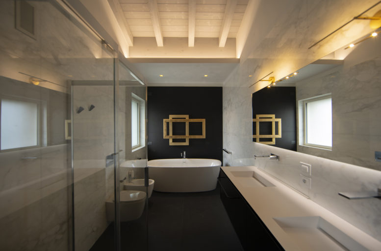 Gold, velvet, fine leather and wood in warm tones, colors that also enter the master bathroom where the protagonist is the radiator in gold leaf finish that stands out on the wall covered in black granite.